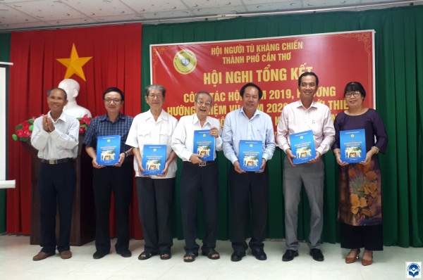 Ông Phan Thanh Sĩ (Chủ tịch Hội Người tù Kháng chiến TP. Cần Thơ, bìa trái) trao tặng tập kỷ yếu đến đại biểu tham dự Hội nghị.